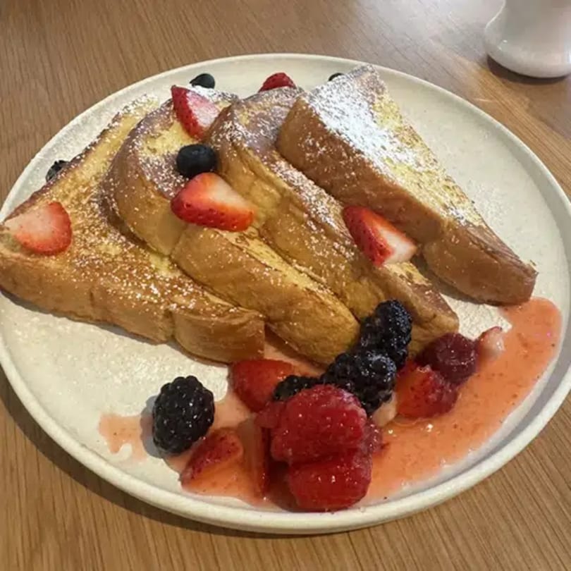 Queen B's French toast with powdered sugar, strawberries, blueberries, raspberries, and blackberries.